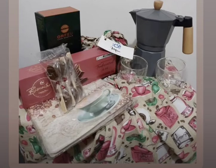 Cafeteira italiana, copos e cafés arrumados sobre o tecido